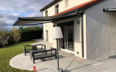 Installation de stores ext&eacute;rieurs avec coffre &agrave; Dommartin, paysage urbain en arri&egrave;re-plan.