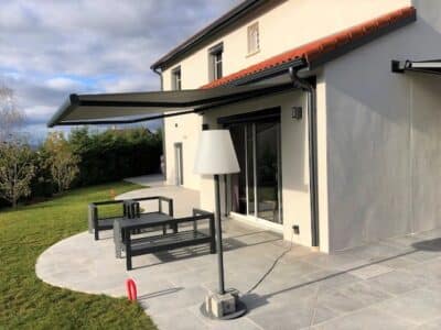 Installation de stores ext&eacute;rieurs avec coffre &agrave; Dommartin, paysage urbain en arri&egrave;re-plan.